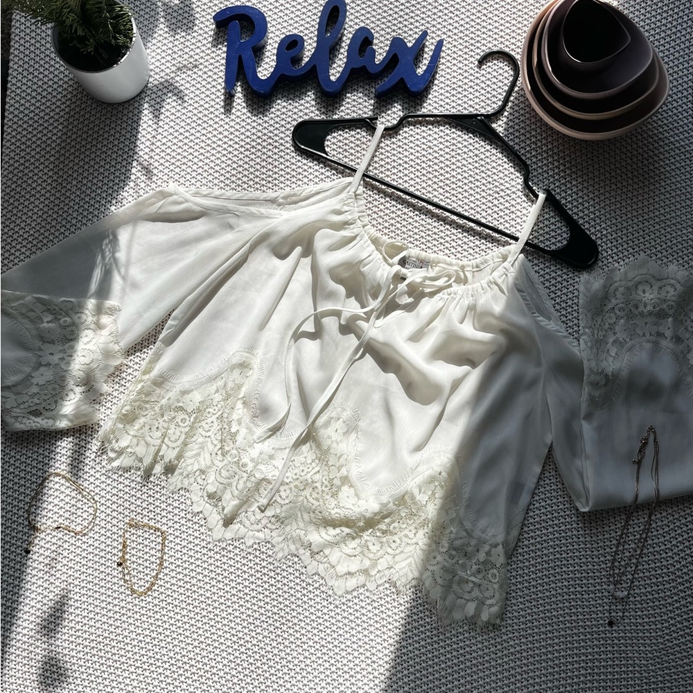 White, off the shoulder, sheer and lace top with elbow length arms.